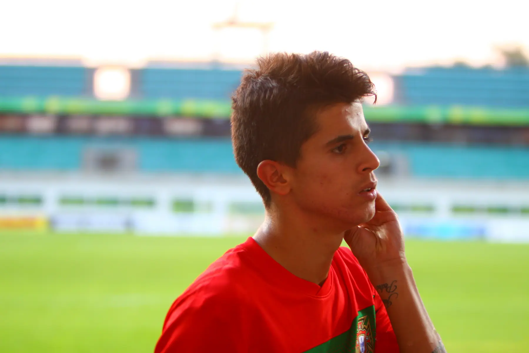 João Cancelo vestindo a camisa da seleção de Portugal em um campo de futebol.